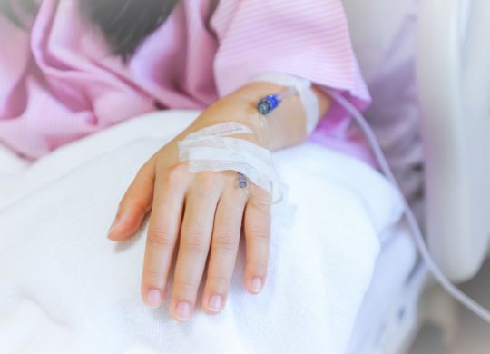 Saline intravenous (iv) drip in a female patient hand